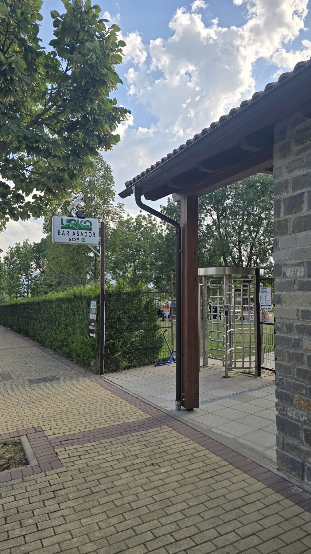 Acceso exterior a Urko Bar Asador con el rótulo del asador y el porche de piedra