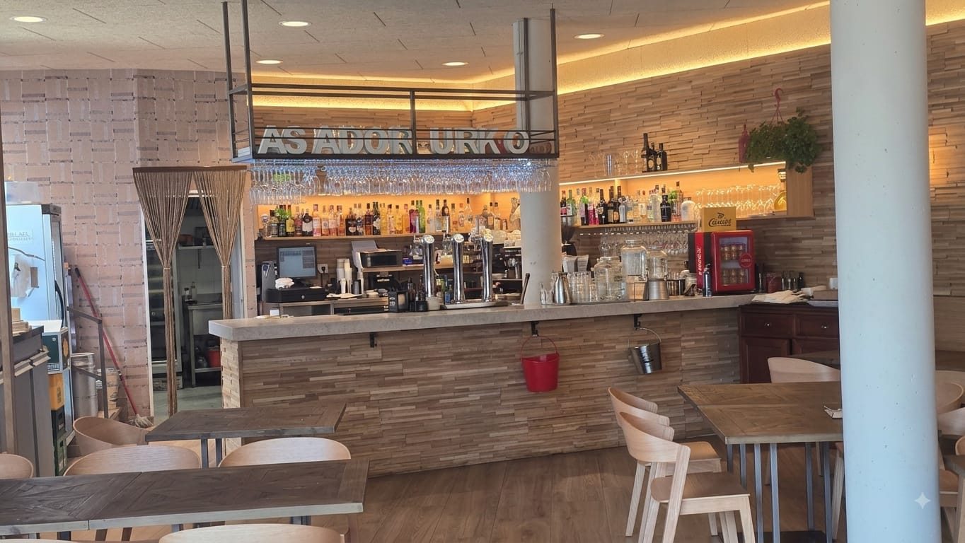 Barra de Urko Bar Asador con el rótulo del asador, copas colgadas y taburetes de madera