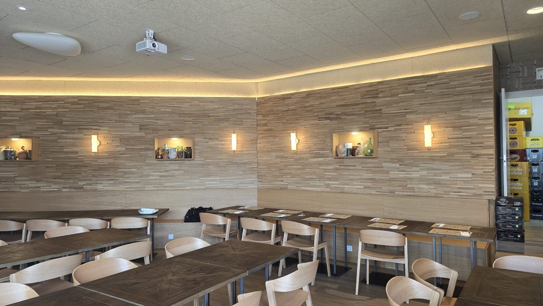 Comedor amplio con mesas alargadas y paredes de madera clara